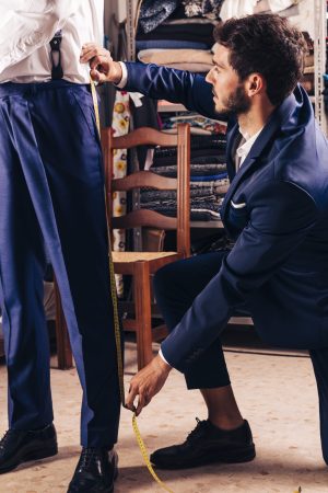 fashion-designer-taking-measurement-male-customer-s-pant-shop